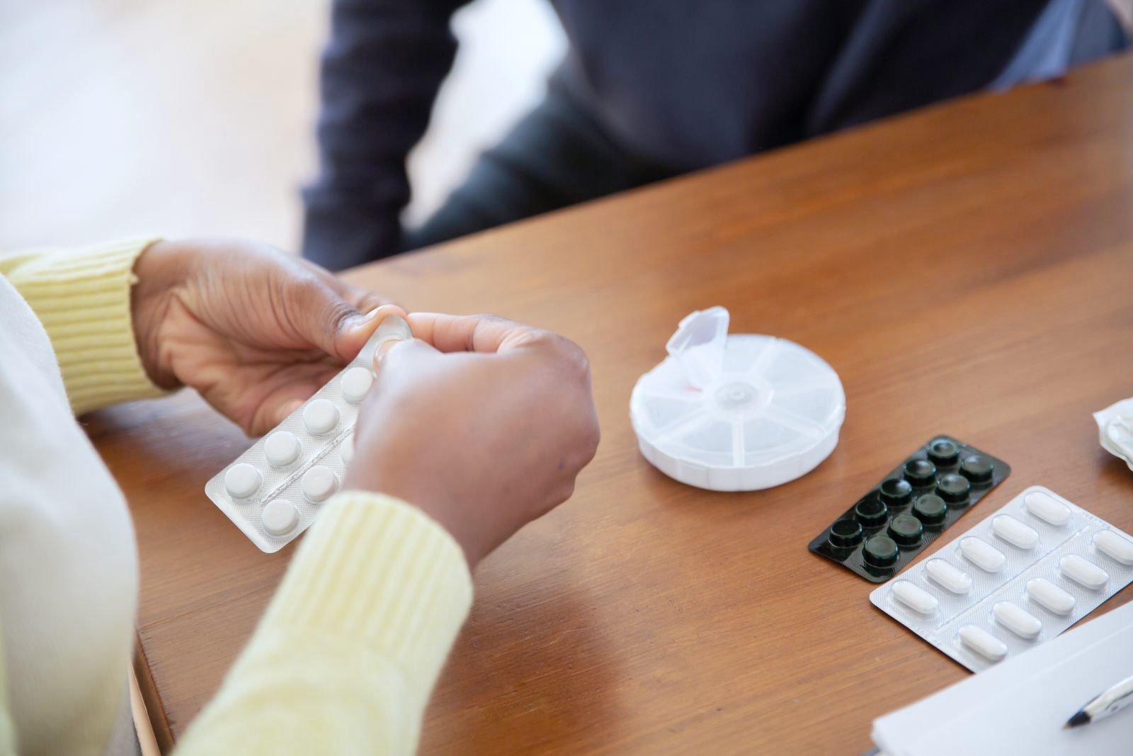 A carer checking an older resident's medicines at a care home