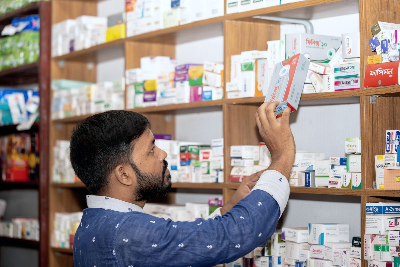 Choosing a medicine from a pharmacy shelf