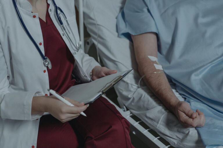 A doctor reviewing a drug chart on a hospital ward