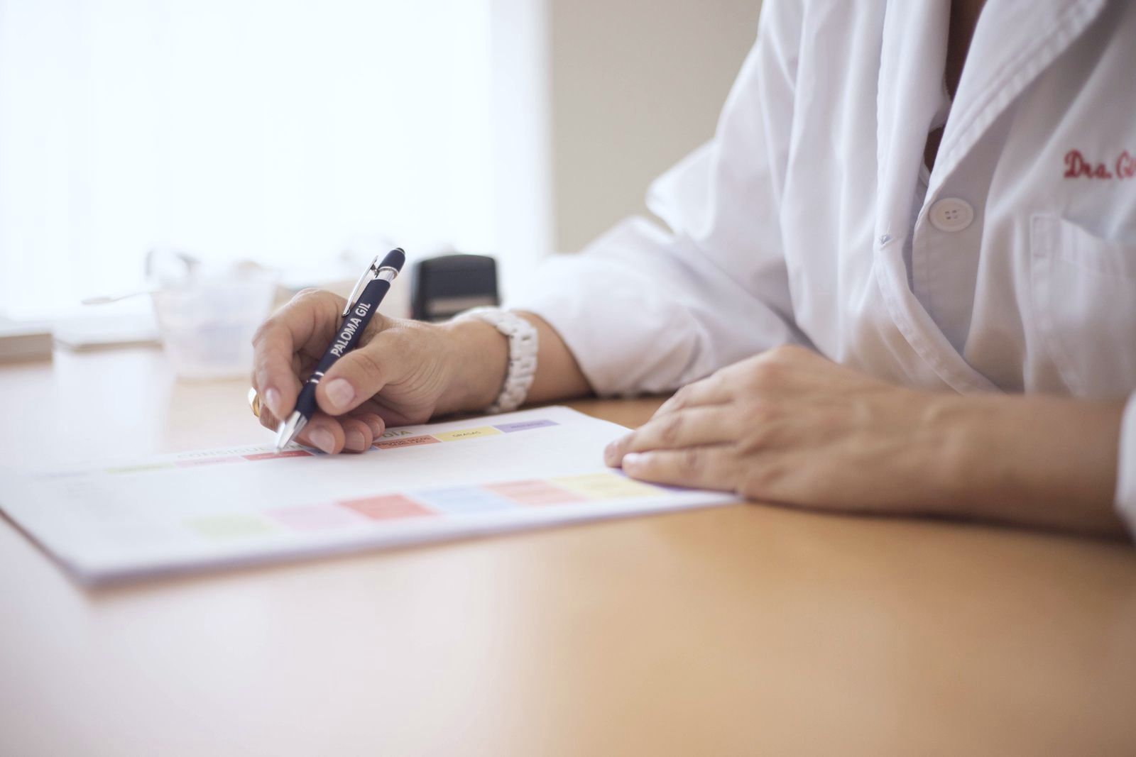 A prescriber writing on a prescription form