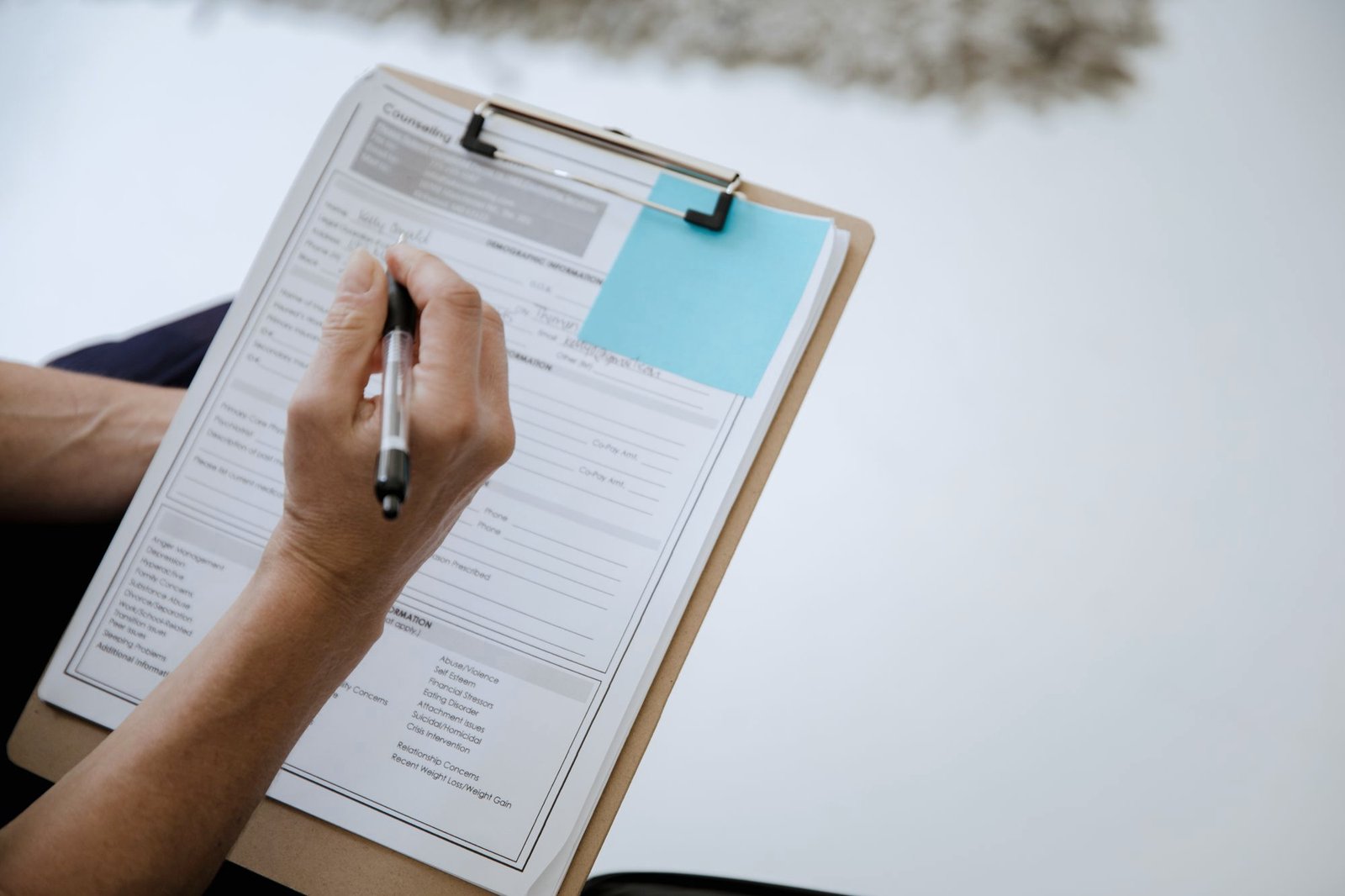A hand ticking off a checklist on a clipboard
