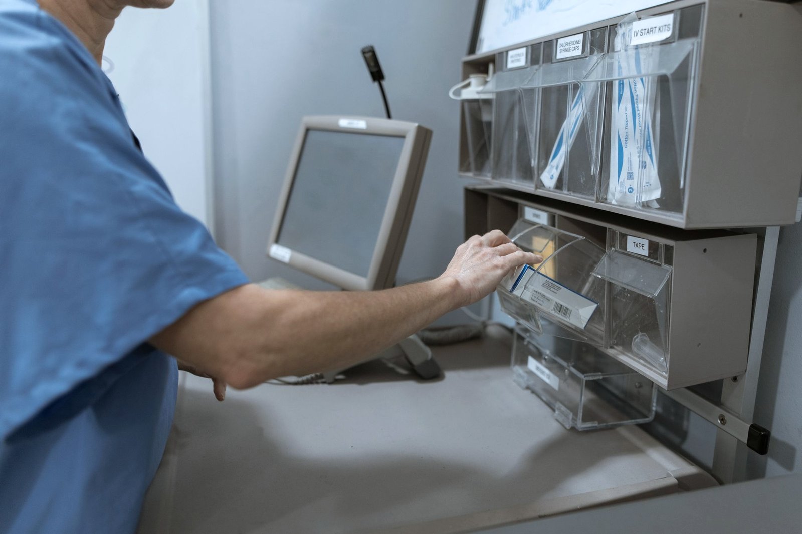 A nurse taking medicine from an electronic medicines cabinet on a hospital ward