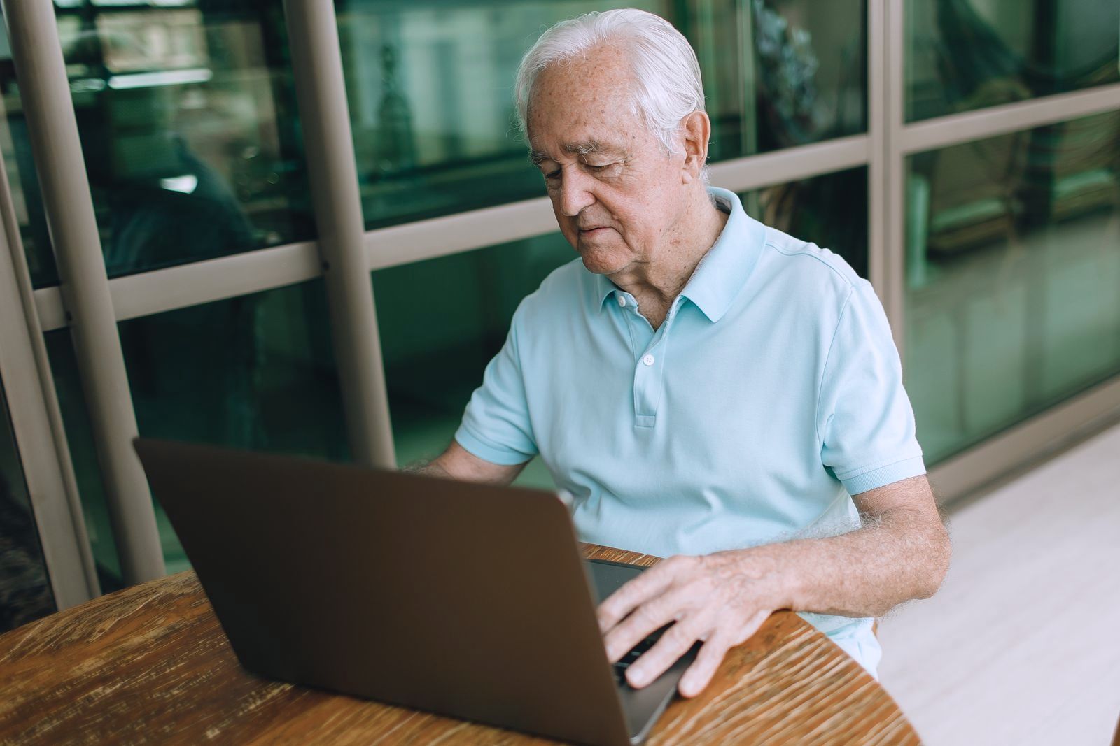 An older man using a laptop at home