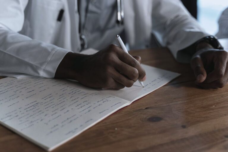 A prescriber writing notes at a desk