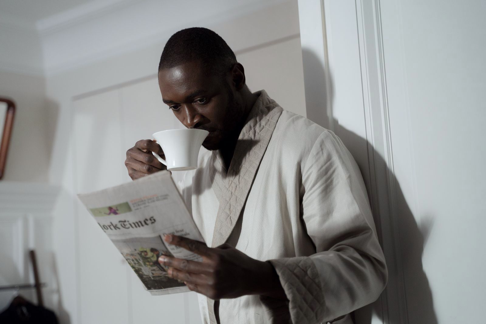 A man reading a newspaper over coffee